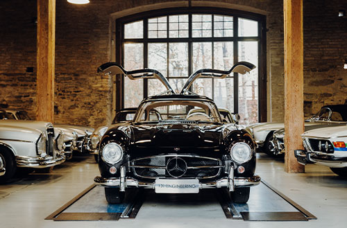 Schwarzer Mercedes-Benz mit Flügeltüren in einer Fahrzeugausstellung.