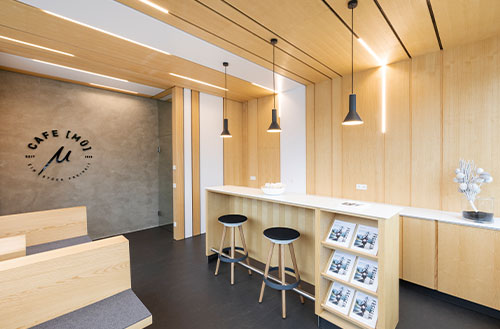 Innenansicht eines modernen Cafés mit Holzverkleidung und minimalistischer Einrichtung.
